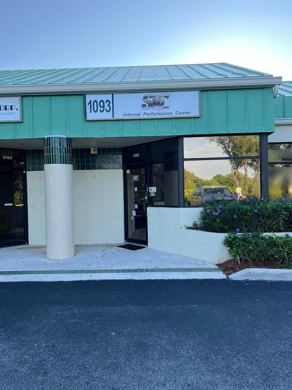 The building entrance at 1093, with the unit number over the door and parking in front